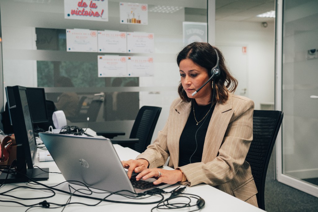 Conseillère Back COMEARTH au casque, concentrée devant son ordinateur