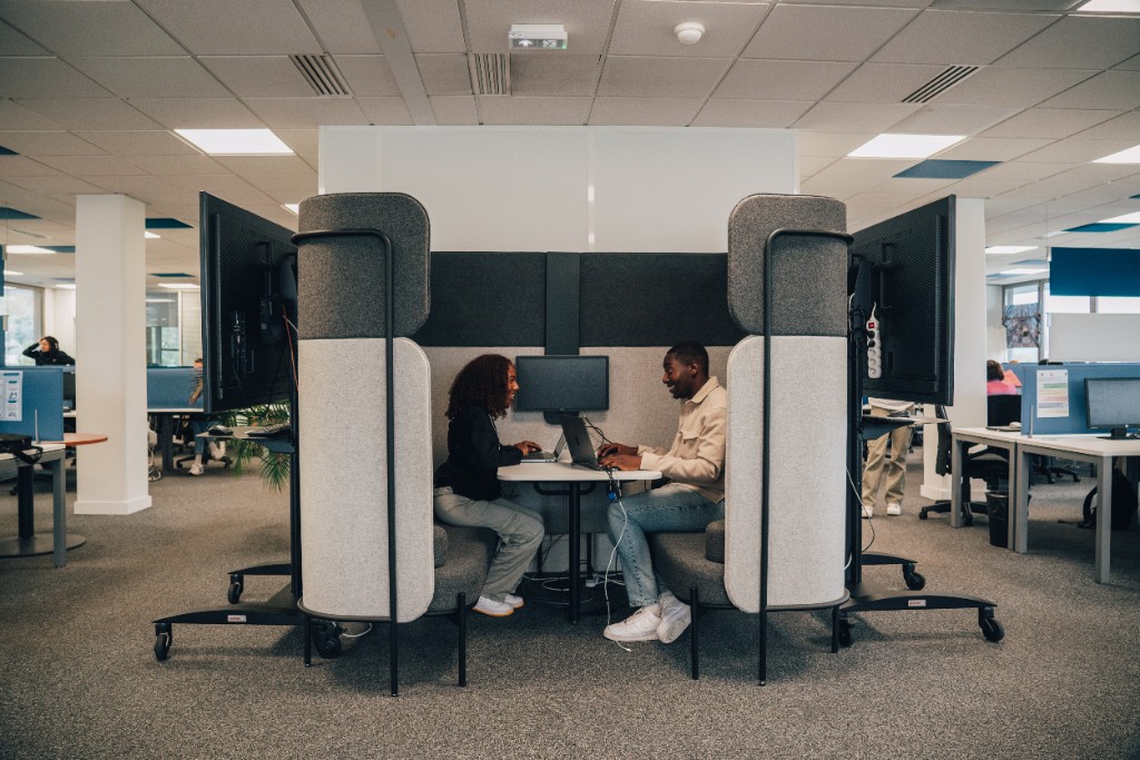 Deux collaborateurs échangent dans un espace de travail partagé
